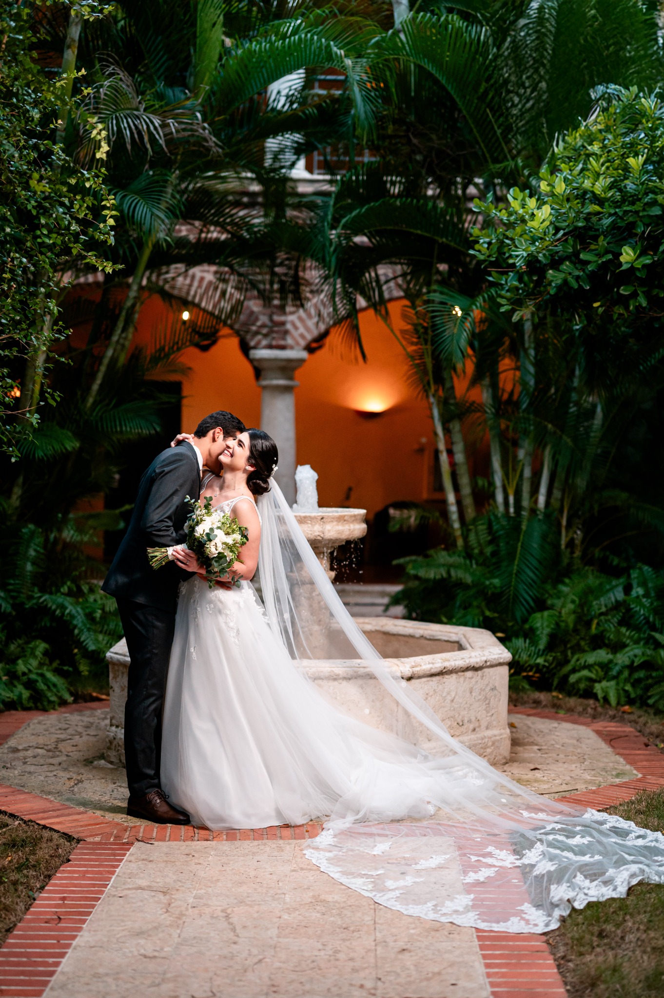 Wedding couple embracing in a tropical colonial garden